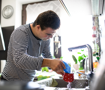 Care worker helping NDIS client with everyday household chores